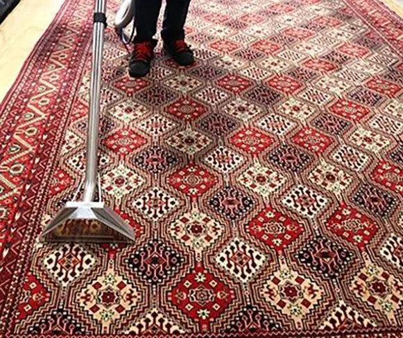 person cleaning oriental rug