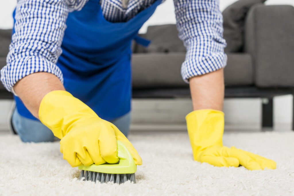 close up man cleaning a carpet